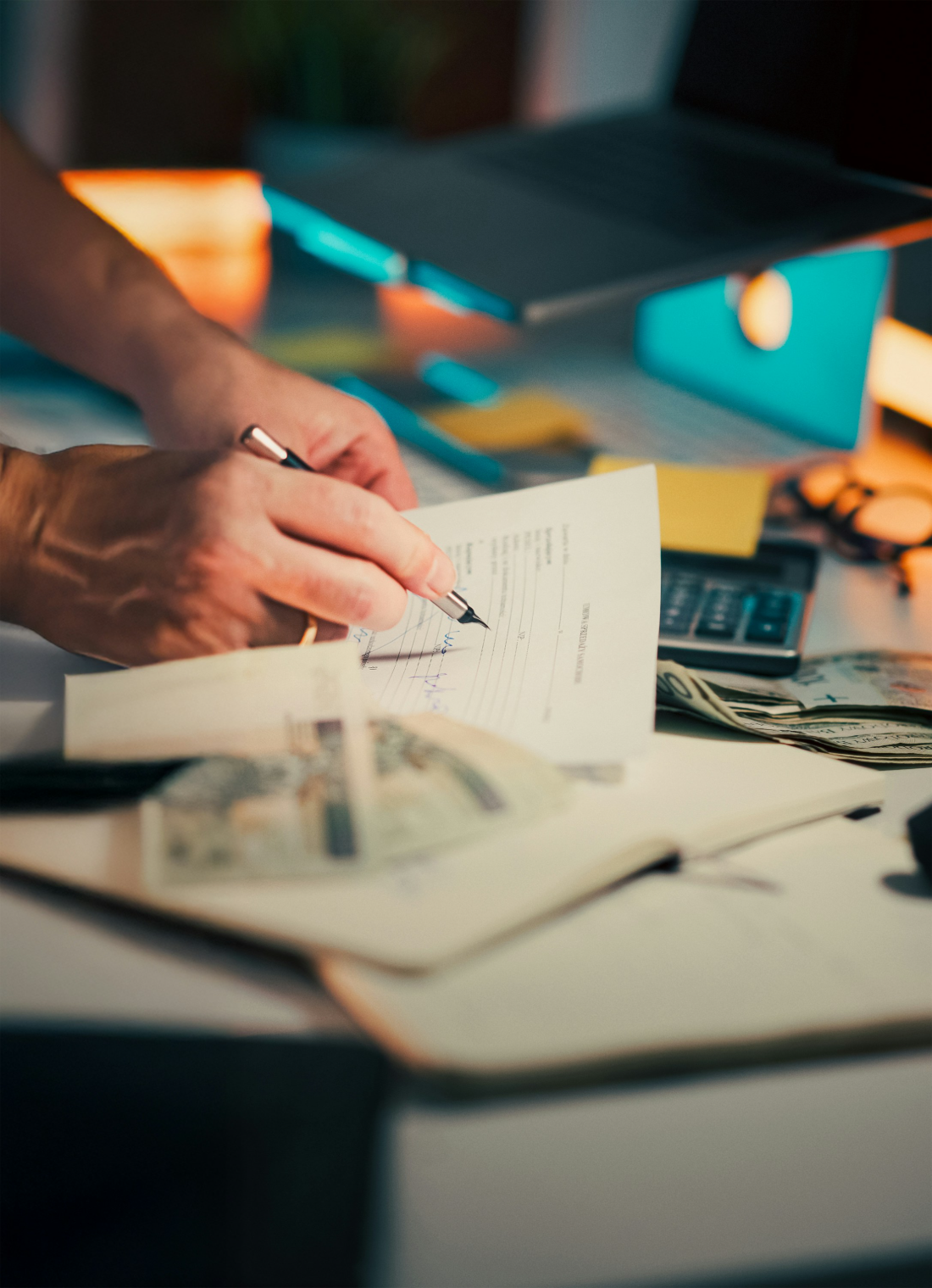 A valuer signing a report at a desk, with calculator and working papers