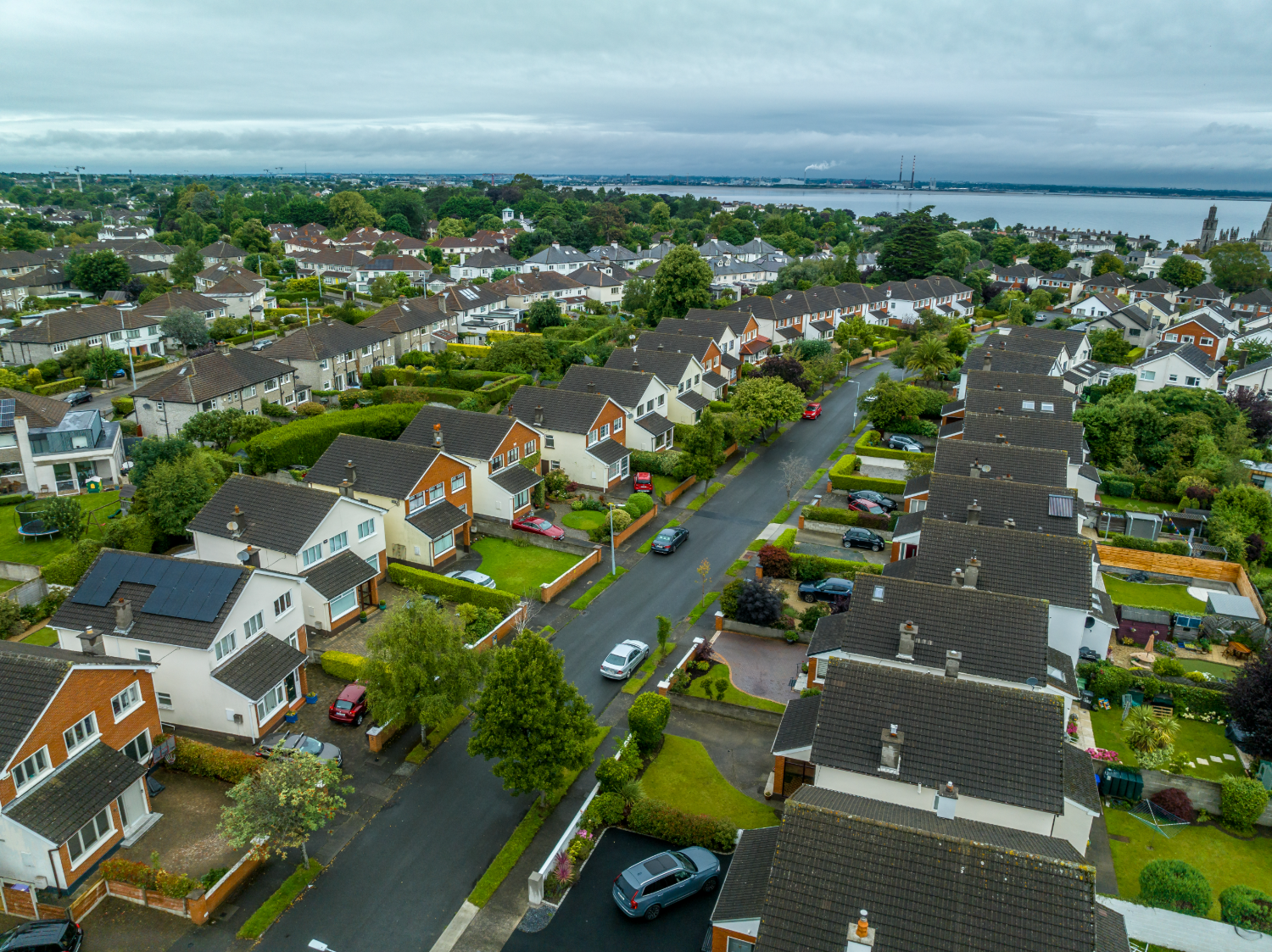 Aerial view of a Dublin residential street, with Dublin Bay and the Poolbeg chimneys beyond